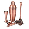 Copper cocktail shaker set with jigger, bar spoon, and strainer on a white background