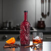 Rusty Barrel Skull-shaped Spiced Rum bottle with a glass of rum on the rocks on a kitchen counter