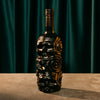 Decorative Rusty Barrel Caribbean Gold Rum bottle with skull design on a dark background