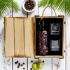 Rusty Barrel Spiced Rum bottle and two glasses in a wooden box with coffee beans and limes on a rustic surface.