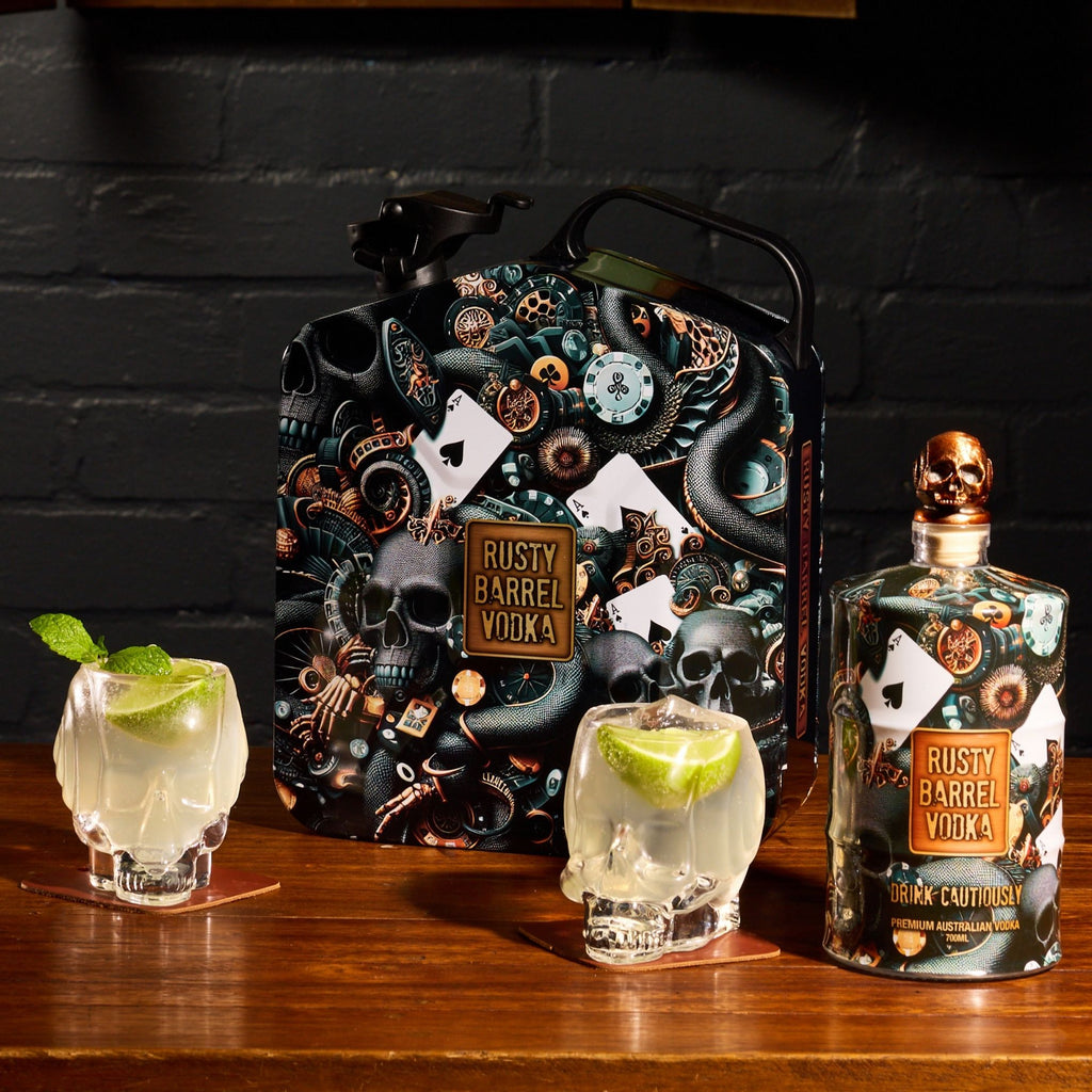 Rusty Barrel Vodka bottle and packaging on a wooden surface with skull glasses.
