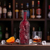 Rusty Barrel Skull-shaped spiced rum bottle with a glass of rum on a bar shelf background