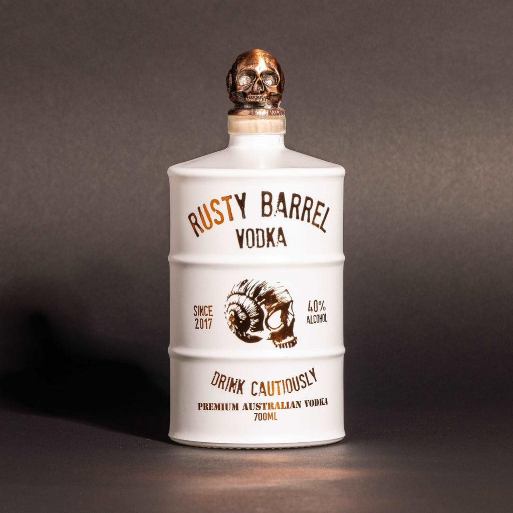 Bottle of Rusty Barrel Vodka 700ml Matte White with skull design on a dark background