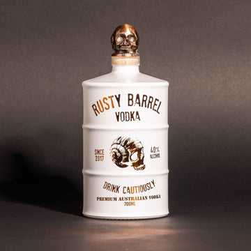Bottle of Rusty Barrel Vodka 700ml Matte White with skull design on a dark background