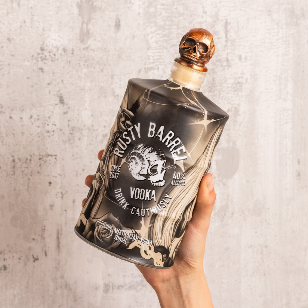 Bottle of Rusty Barrel Vodka 700ml Deadmind Tattoo held against a textured gray background