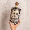 Bottle or Rusty Barrel Vodka 700ml Deadmind Tattoo with artistic label held by a hand against a textured gray background