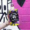 Bottle of Rusty Barrel Vodka 700ml Yellow Wildstyle held in front of a colorful graffiti wall.