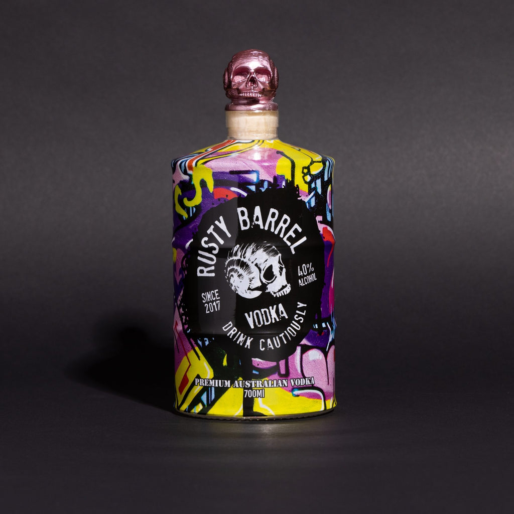 Colorful bottle of Rusty Barrel Vodka 700ml Yellow Wildstyle with a skull design on a dark background
